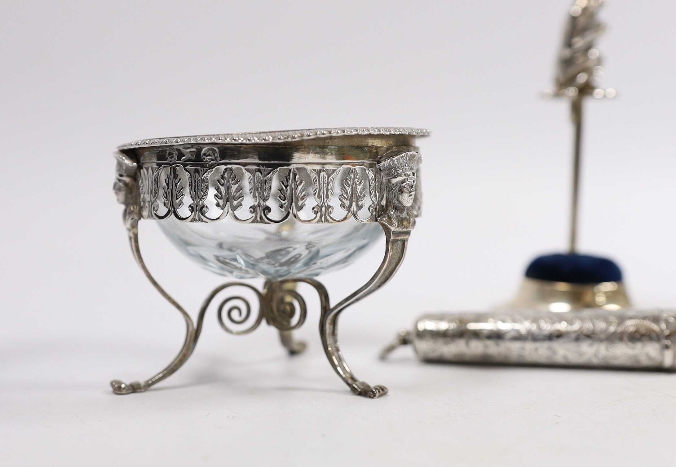 A pair of continental white metal mounted glass cauldron salts, with one associated spoon, an Edwardian silver mounted ring tree/hat pin stand, with monkey surmount, Birmingham, 1909, 10.2cm, a silver cheroot case and a